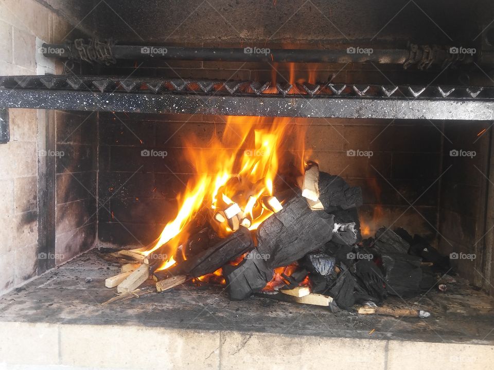 Grill with fire on to prepare roast (Asado).