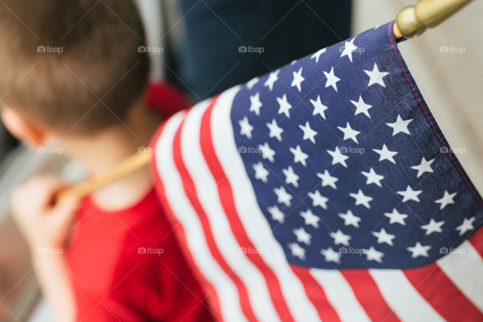 Boy holding USA flag over shoulder 