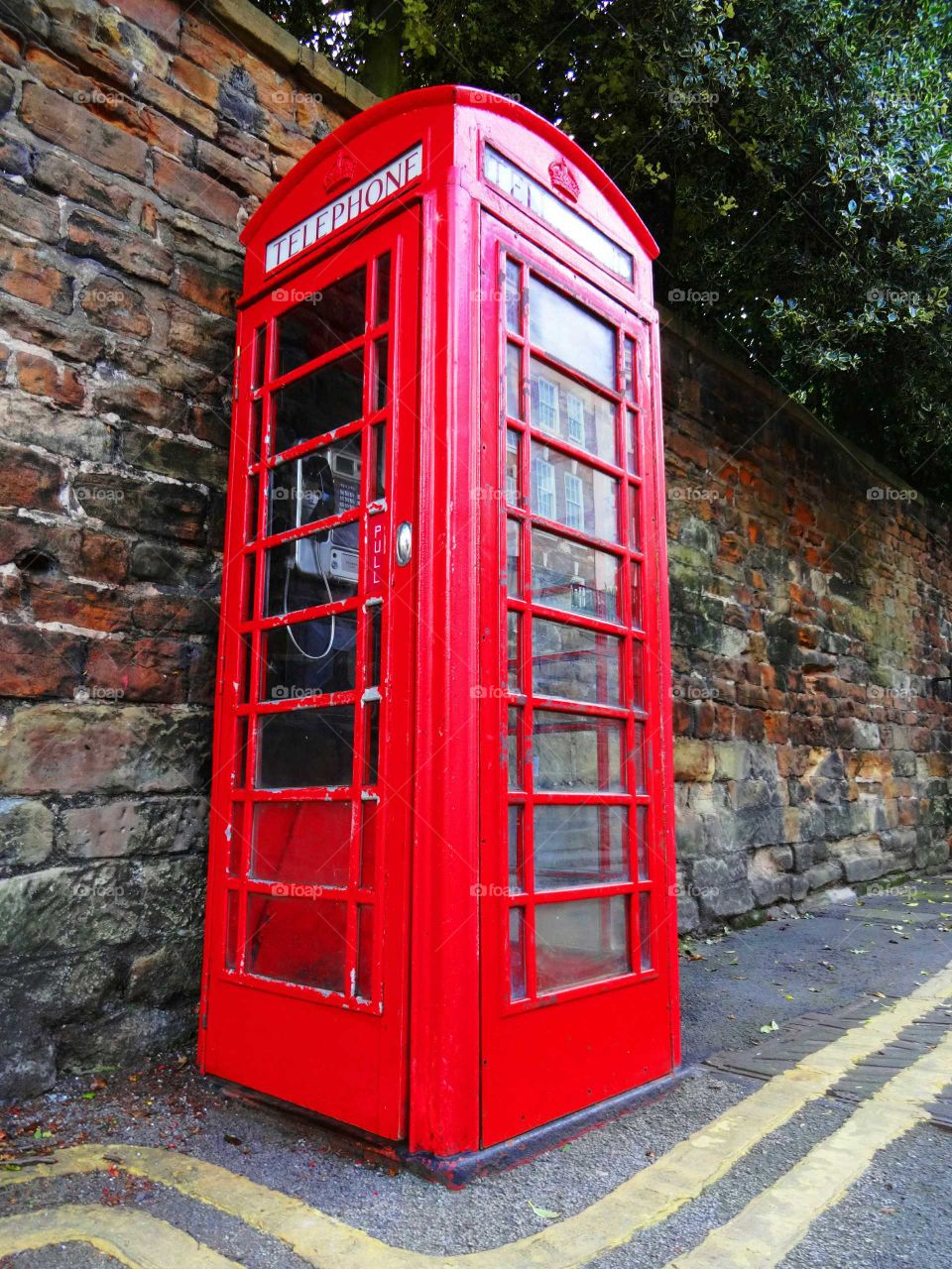 The British red phone booth on old wall