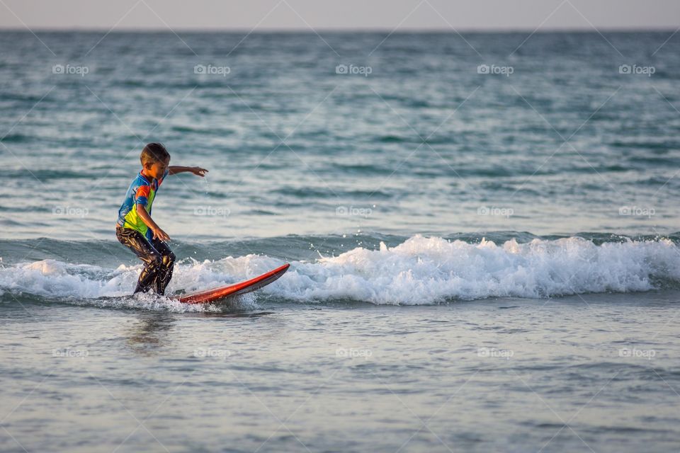 Young Tip of Borneo local lad learns to surf on a donated surf board. 