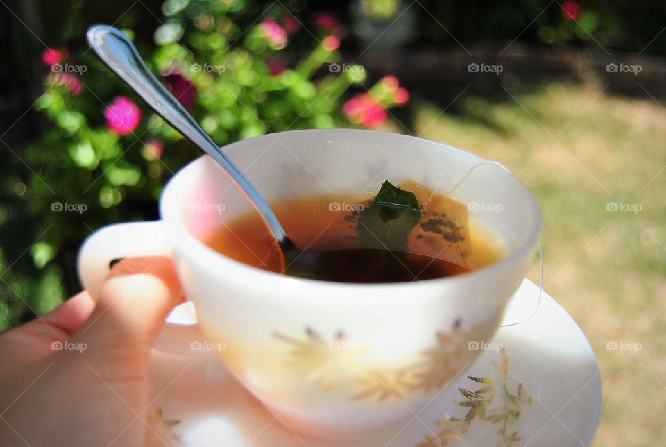 Hand holding cup of tea