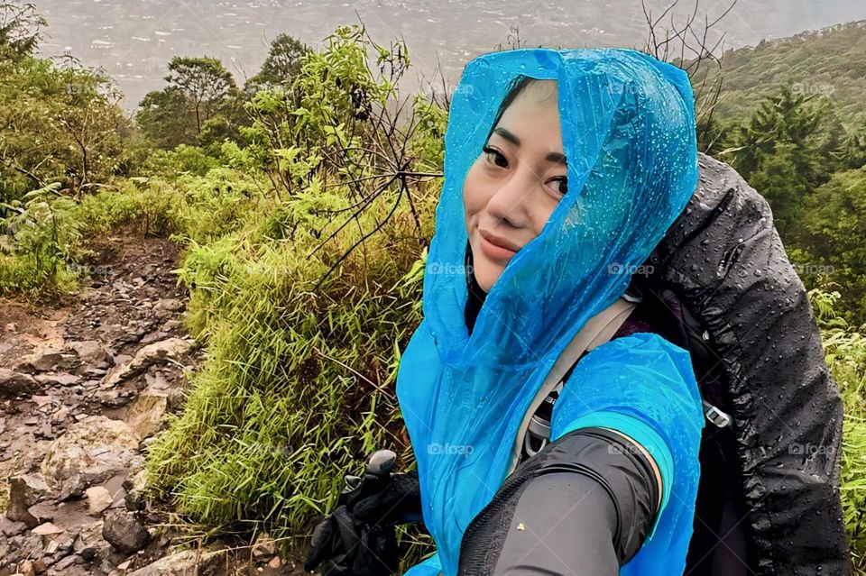 Portrait of young woman wearing raincoat with smile