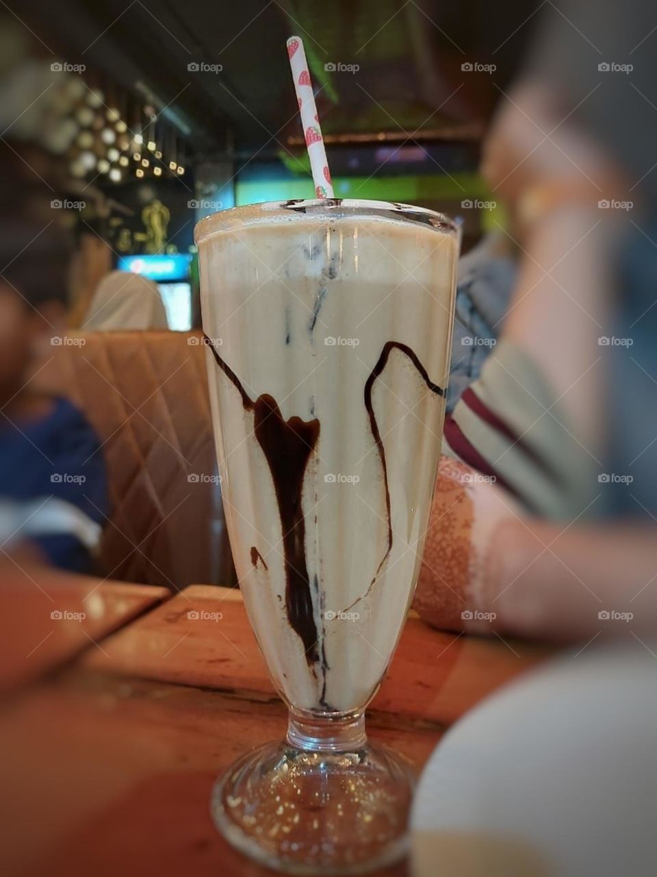 That milkshake looks absolutely scrumptious! The chocolate swirls and the straw make it even more tempting.