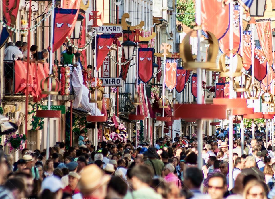 The city streets of Tomar in Portugal, packed out and decorated with flags for a citywide summer festival