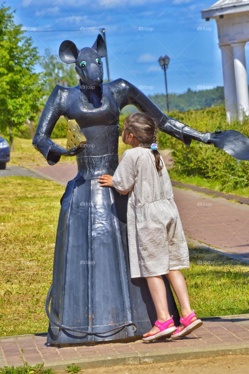 a little girl stood up on her toes to ask something from a fairy-tale character