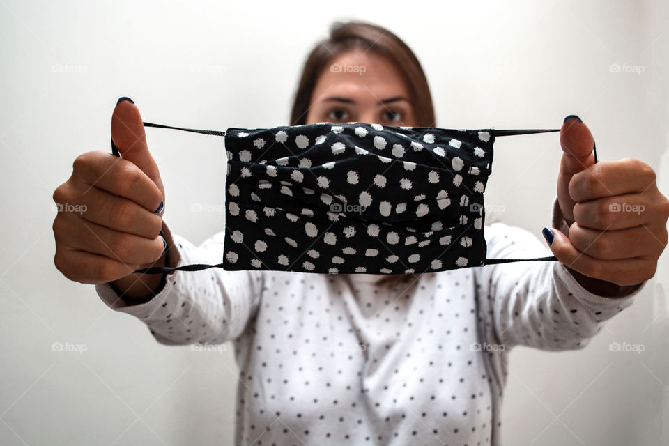 Woman holding a face mask in front of herself