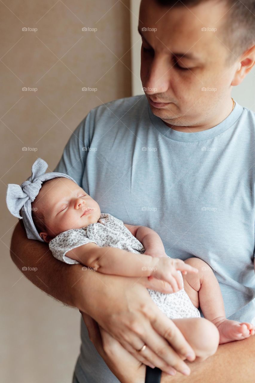 Happy father holding newborn baby daughter 