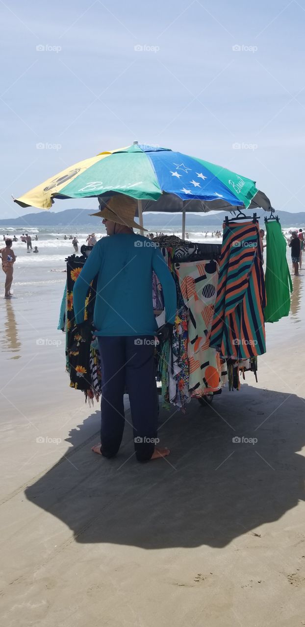 Vendedor ambulante trabalhando na praia.