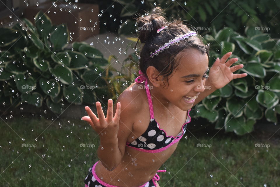 summer fun. playing with the water hose making for a fun summer day
