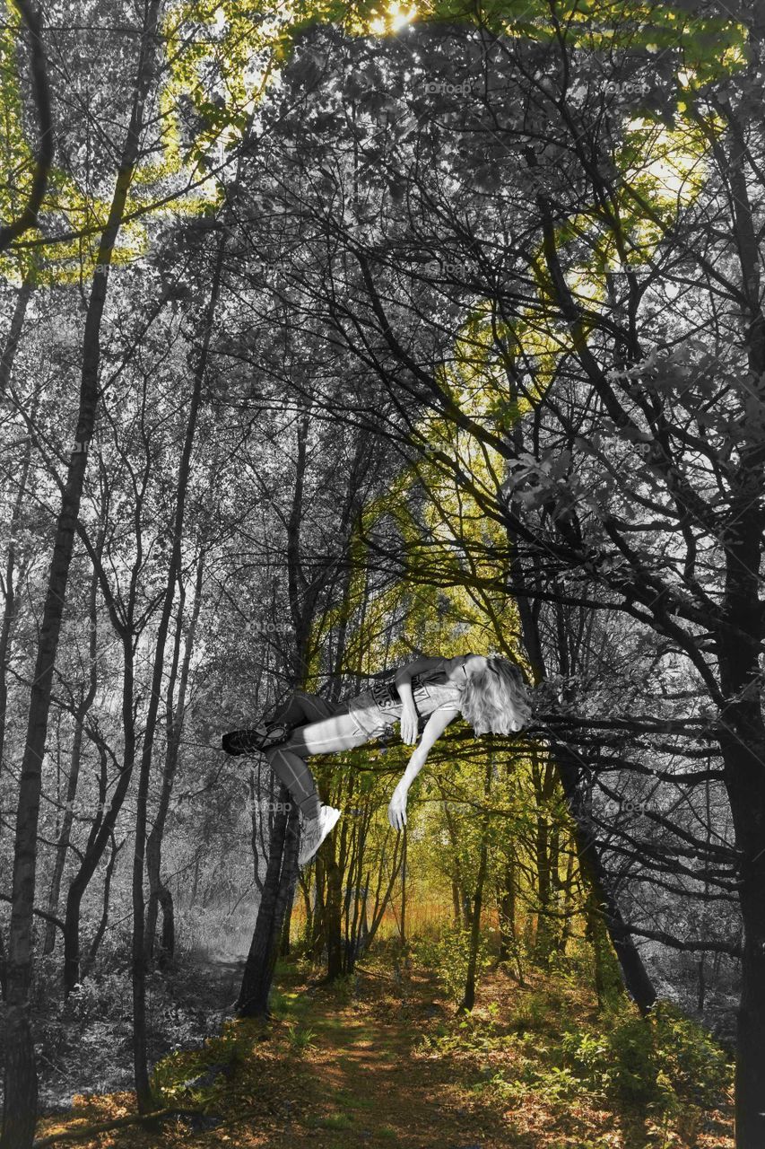 woman relaxing on branch in tree nlack and white with color effects