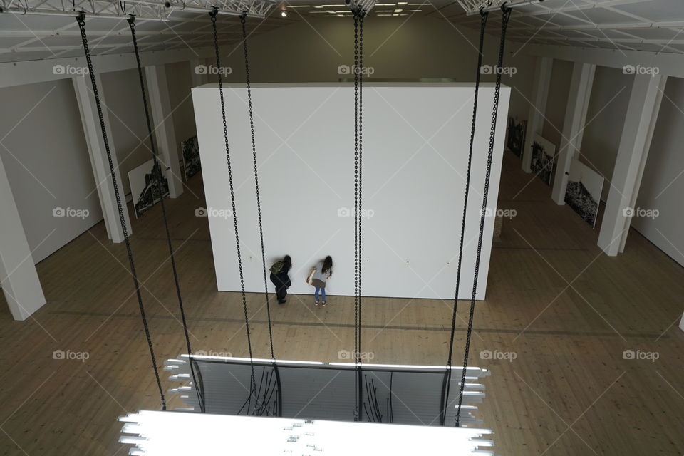 Two girls peeping through keyholes on an art display 