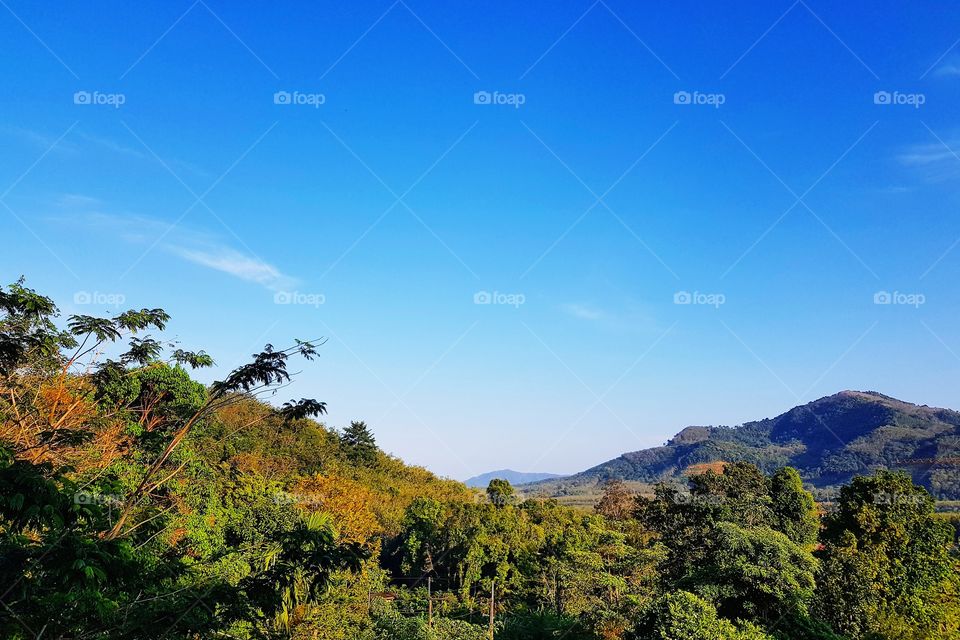 Scenic view of mountain against blue sky