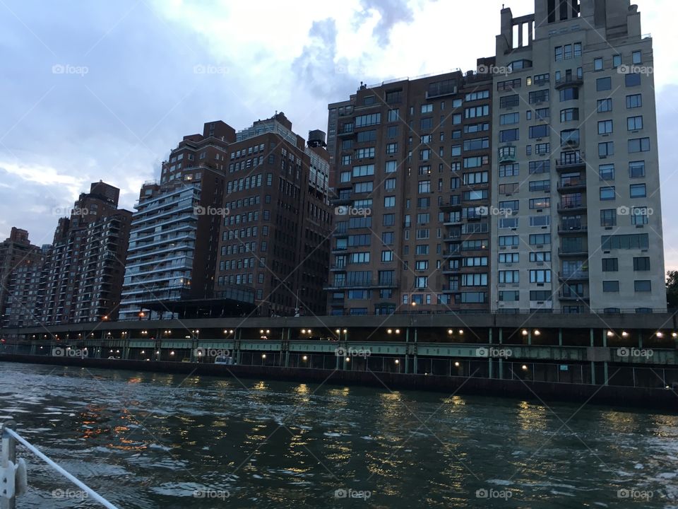 A twilight time view of Manhattan’s Upper East Side from aboard our sailboat, the „Salvation“ traveling southbound towards Newtown Creek in Long Island City, Queens. 2017. Hypnotic Productions