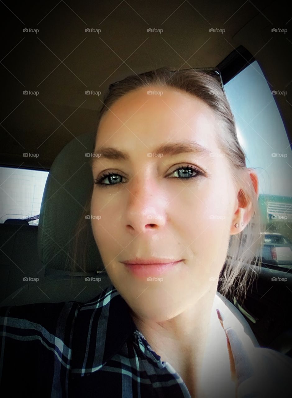 girl sitting in a car looking at camera with slight smile