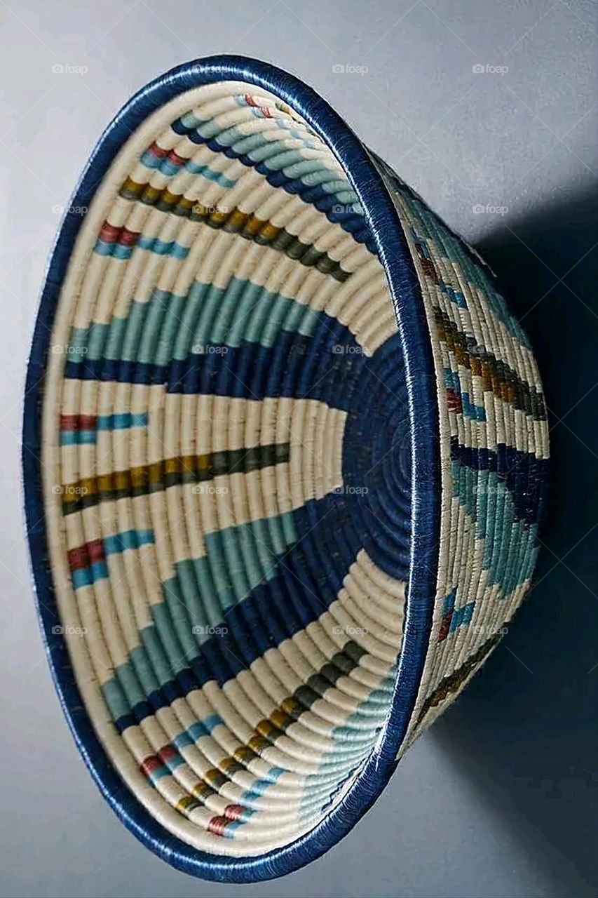 The image shows a group of hand -made dishes of wicker, decorated with colored embroideries with beautiful floral shapes, and is elegantly displayed in a warm corner that combines heritage and beauty, which gives the place an artistic spirit and attr