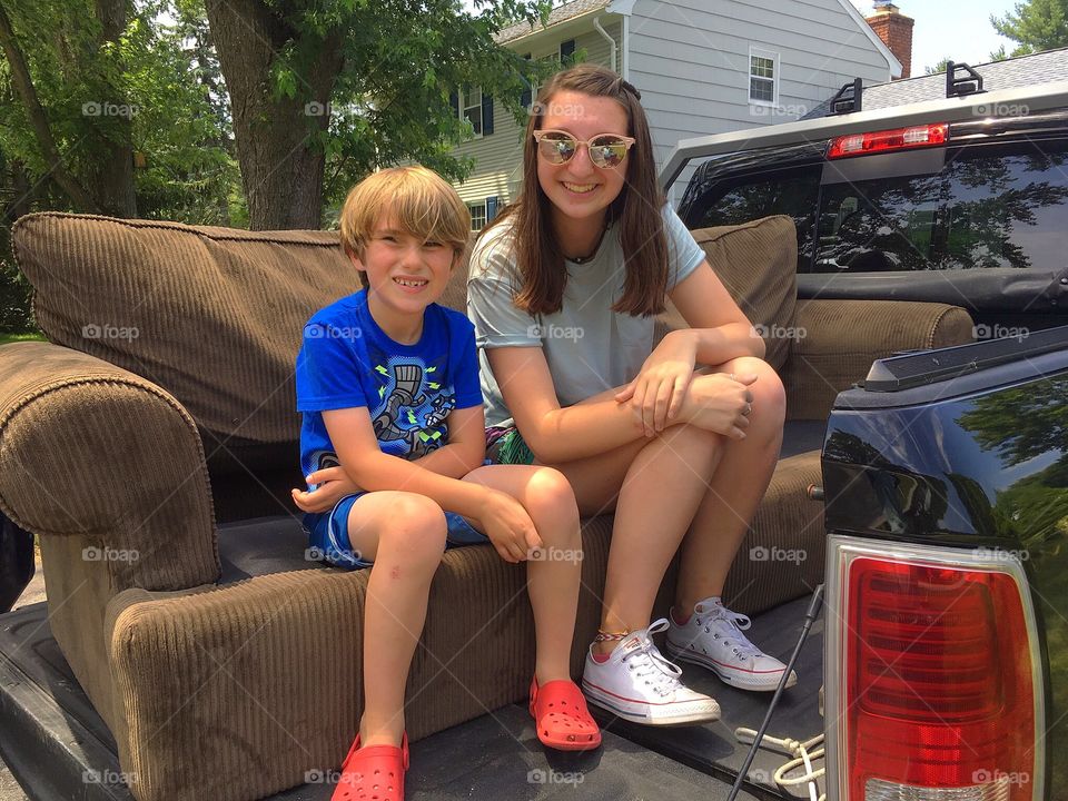 Cousins.  Taking a break from moving into a new house for a picture together.  Summertime, hot, smiling 