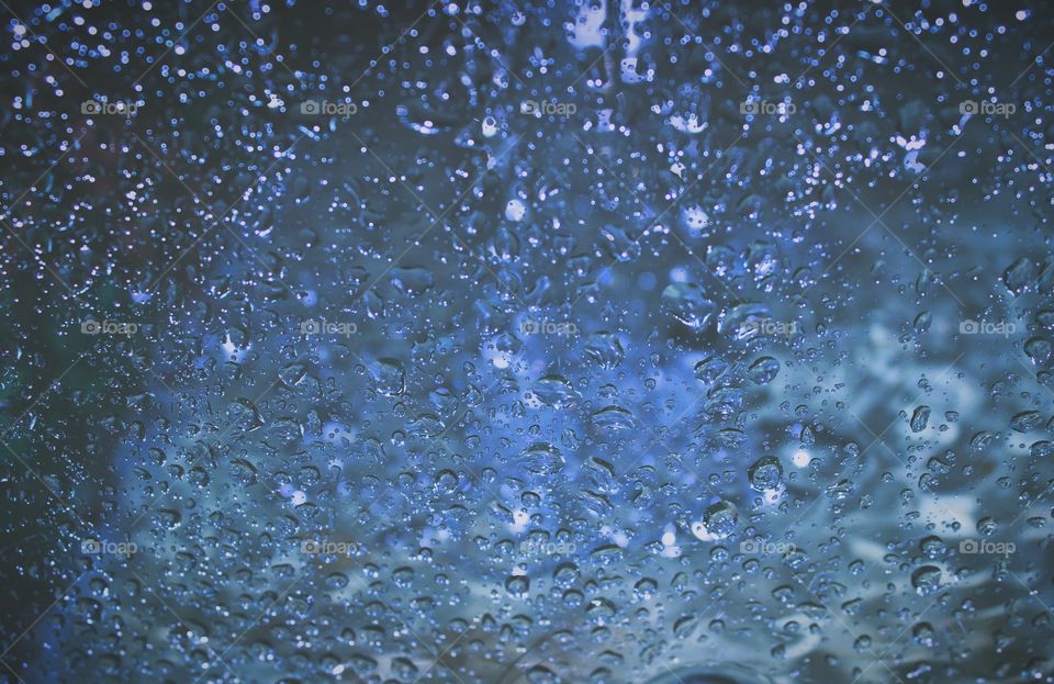 The glass was splashed by rain, causing water bubbles to form and blocking the view outside