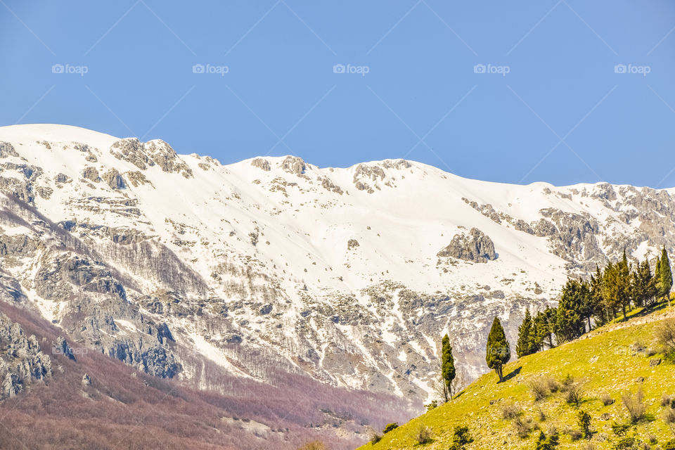 Rural Landscape With Snowy And Green Mountains
