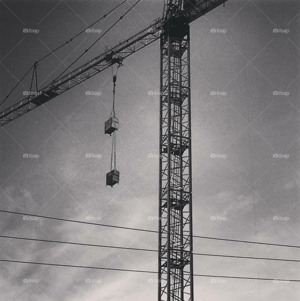 black and white image of a crane with an overcast sky