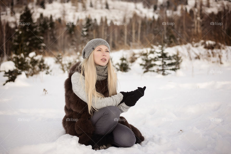 Portrait of young woman sitting on snow