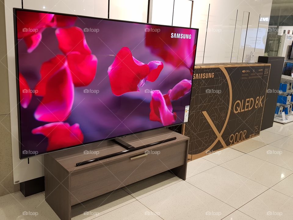 Samsung 75" 4K UHD QLED television on wooden TV stand at Peter Jones Sloane square Chelsea King's road London