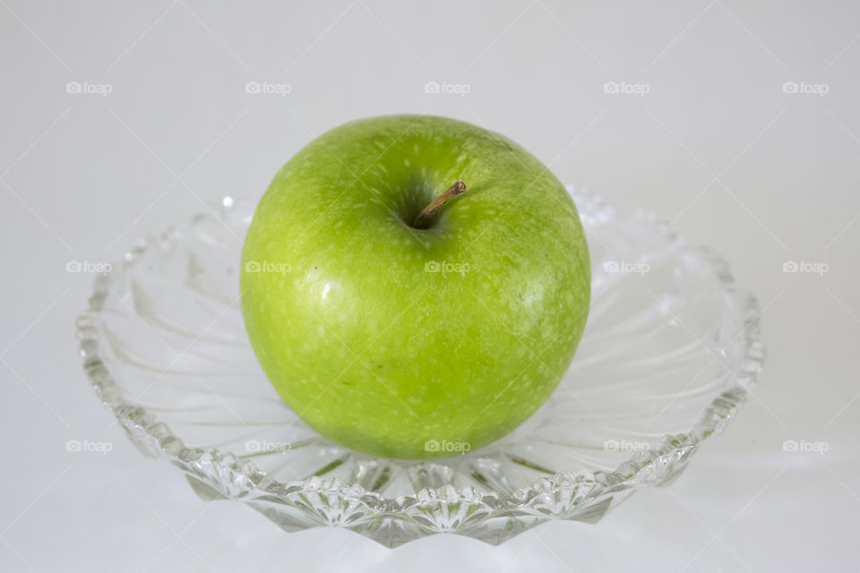 Green apple on crystal plate 