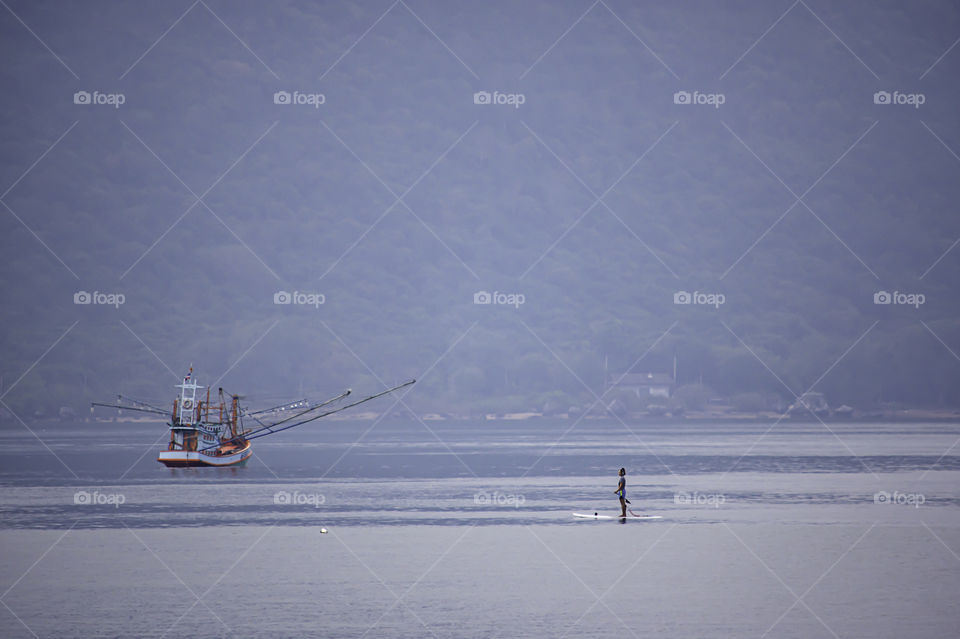 Tourists on surf boards in the sea at Prachuap Bay in Thailand.