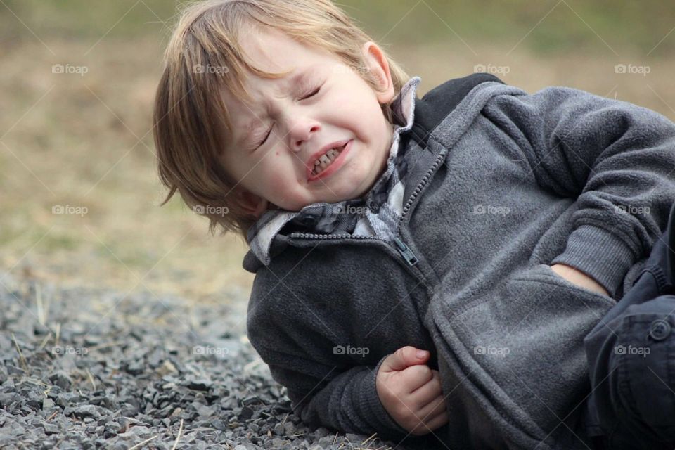 Close-up of a boy lying in stones