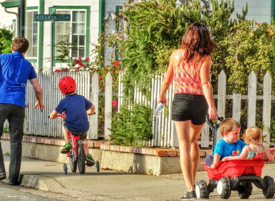 Family With Kids Walking On A City Sidewalk