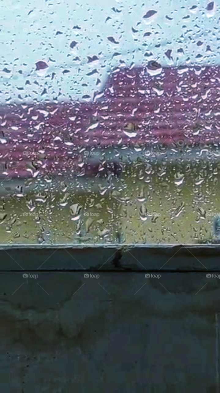 Behind the window the raindrops can be seen clearly