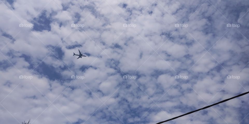 the plane ia flying ini the sky between beautiful clouds