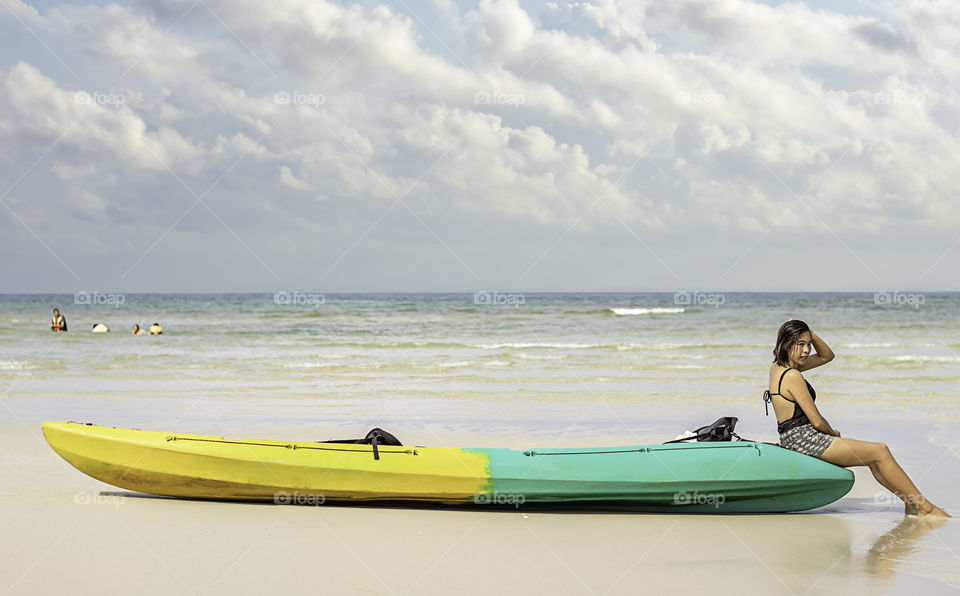 Asian women and kayaks on the beach Background sea and sky at Koh Kood, Trat in Thailand.