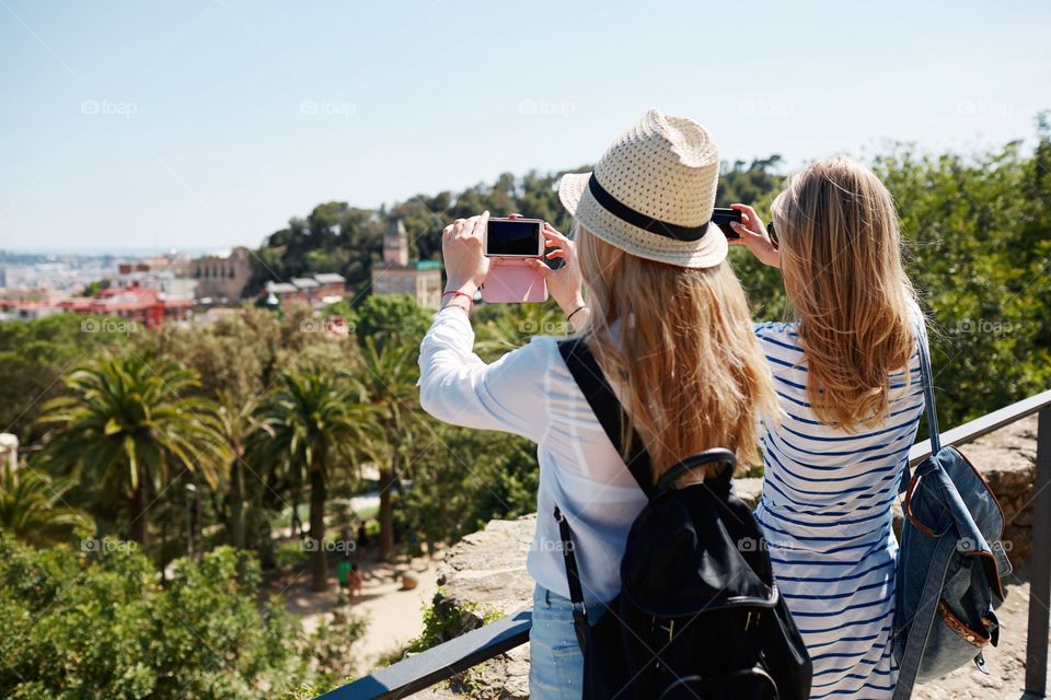 Couple tourists taking photo landscape with camera phone on park. Happy cheerful young multicultural couple friends on travel.