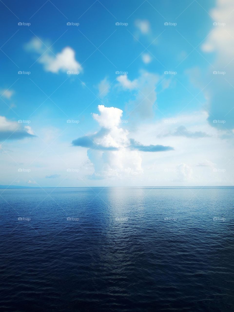 View of the calm sea in the morning and unique cumulonimbus clouds in the blue sky.