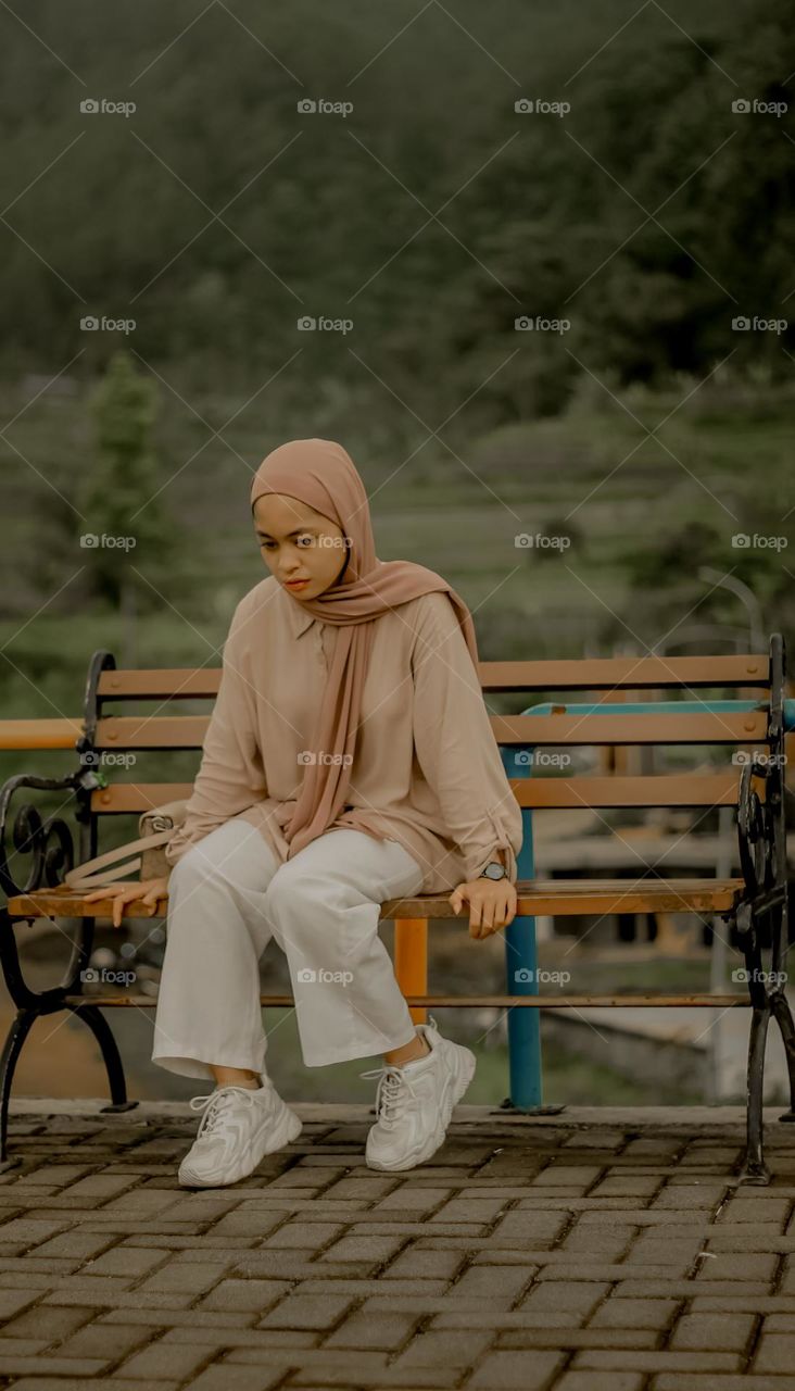 a girl sitting on a park bench