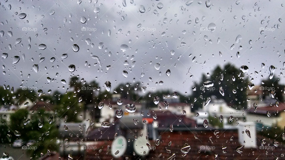 Top view of wet window with rain drops in autumn cold day close up. Weather