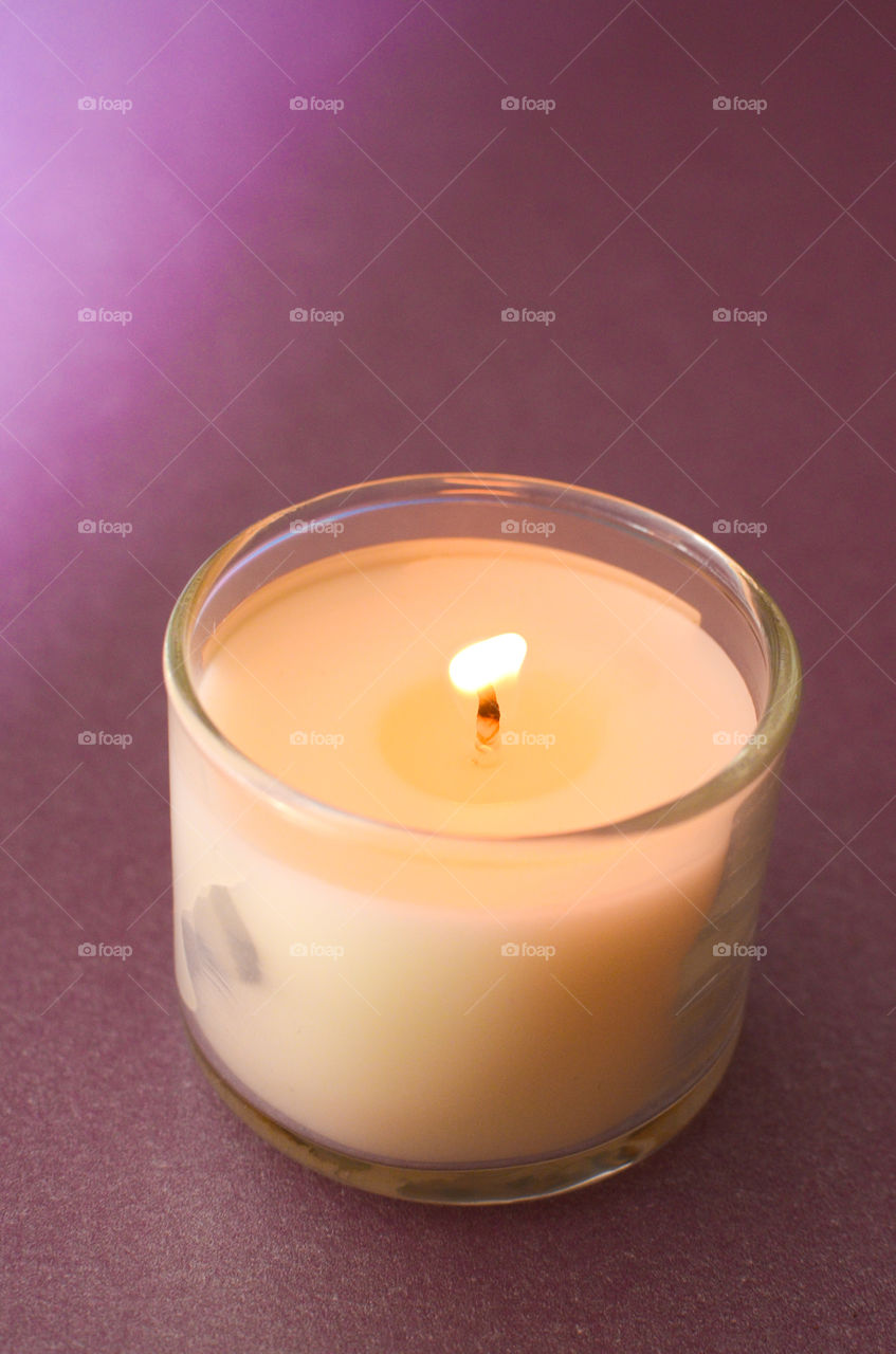 White candle on purple background