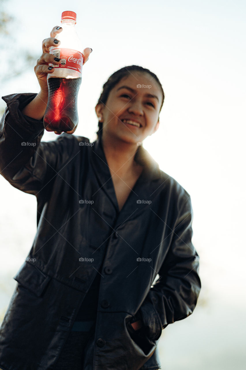 Girl very happy to enjoy a delicious Coca Cola on a sunny day
