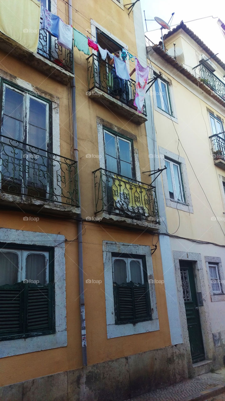 linen is dried on the windows of old houses in Lisbon