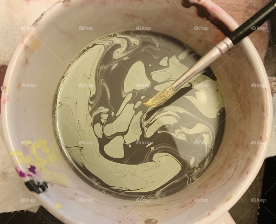 Mixing colors of paint together with a paintbrush 
