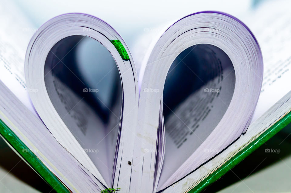 Heart shape make from fold page. Isolated white background. Close up. Togetherness composition. Valentines day friendship day background texture.