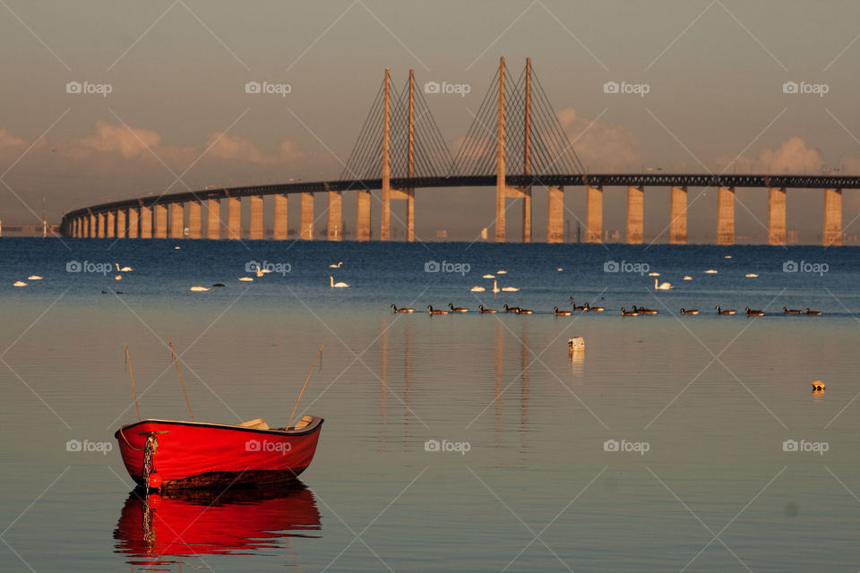 Empty boat in sea during sunset