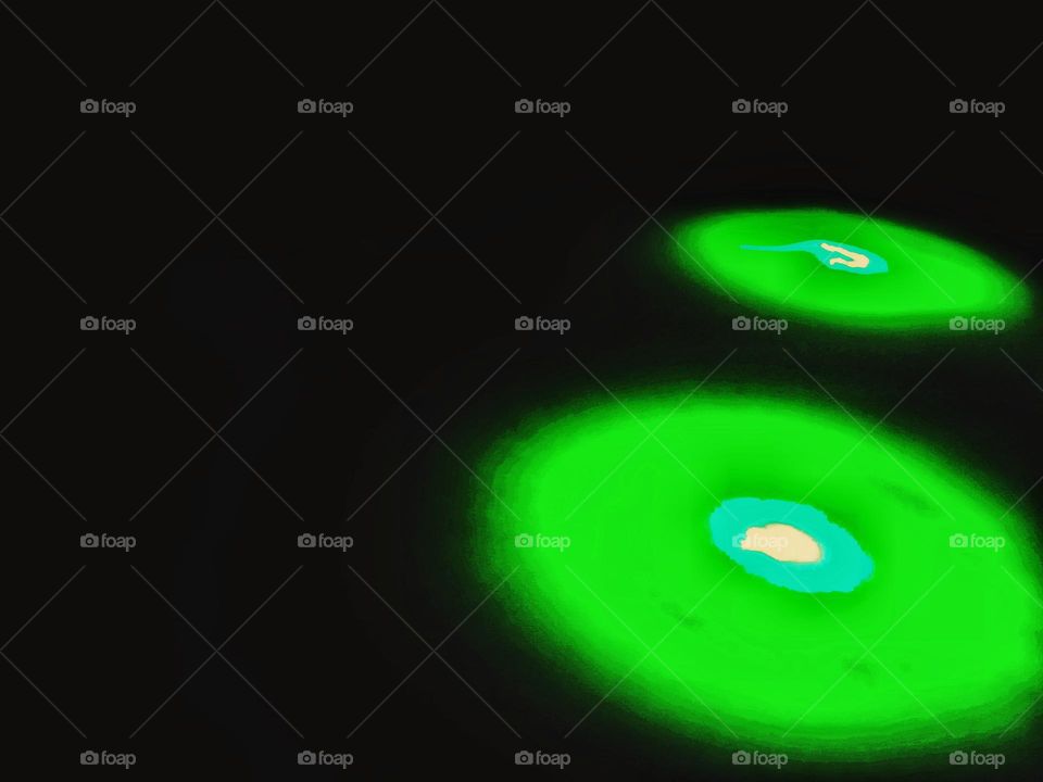 Abstract background of green light from the pointer tool forms like 2 outer space objects with black background
