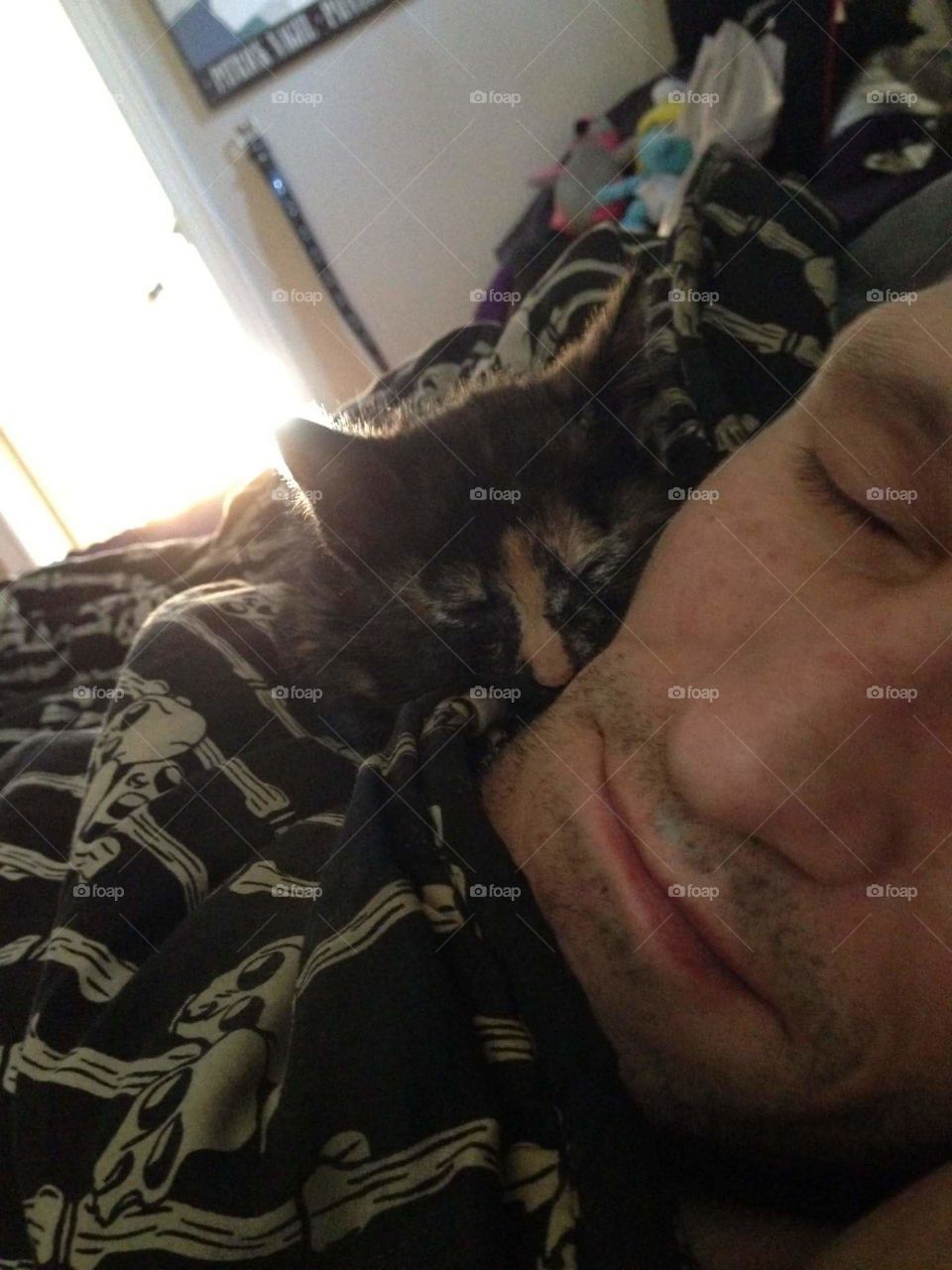 My hubby and my little Circe kitty asleep together.