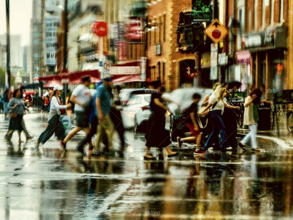 People rushing downtown during a surprise rain storm.