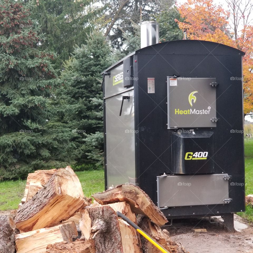 Outdoor wood boiler with fire wood.