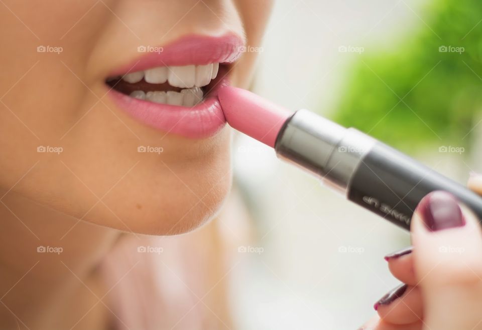 Close up cropped half face portrait, woman holding pink lipstick