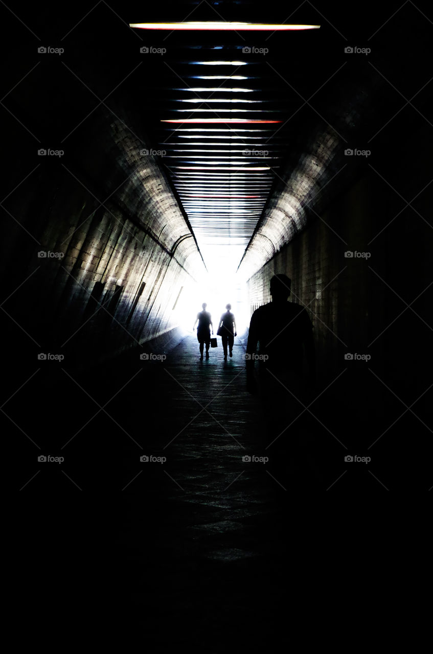 Silhouettes of people inside a tunnel.