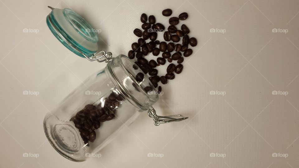 coffee beens and clear glasses container