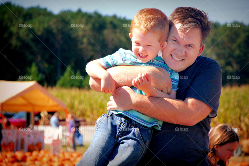 Father and son having Fun Pum. Pumpkin Patch fun.
